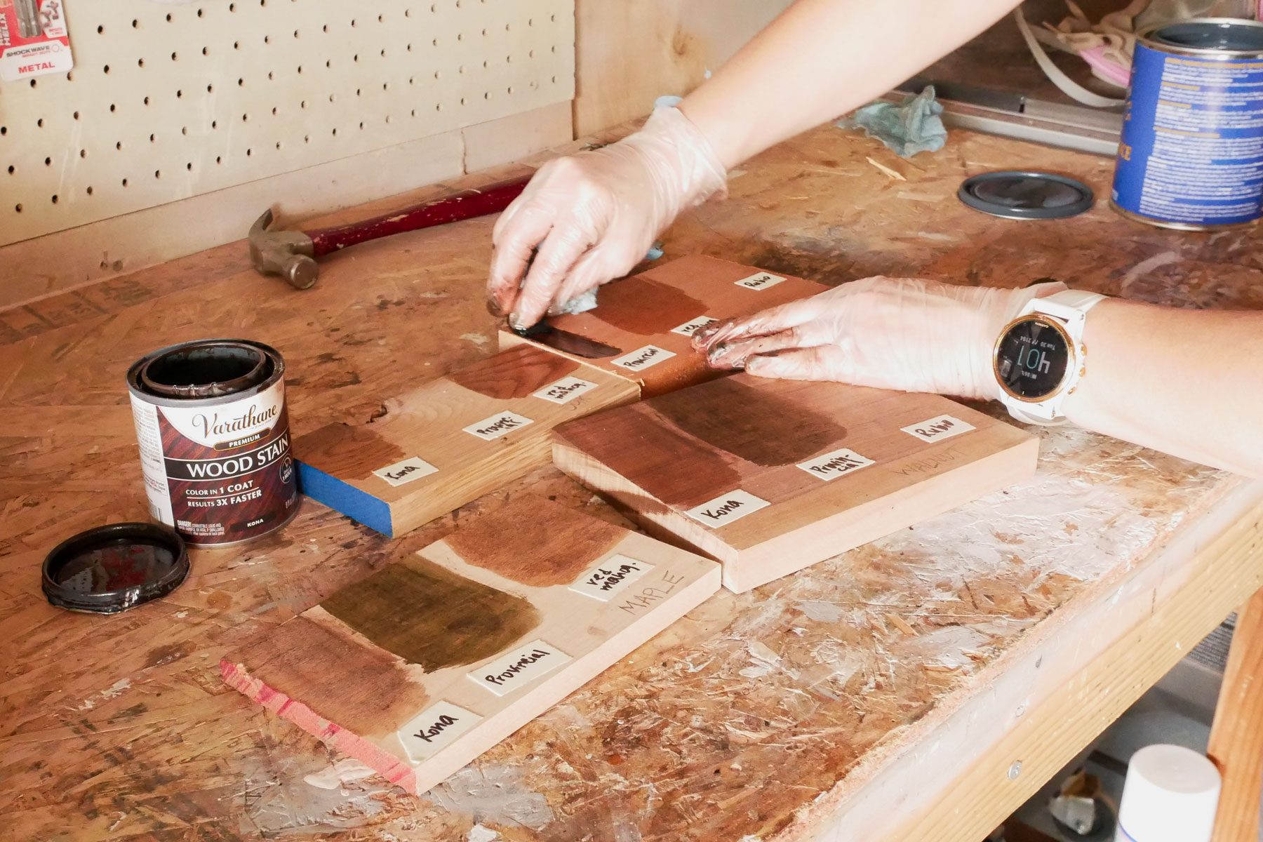 A person applying test stains on wooden boards