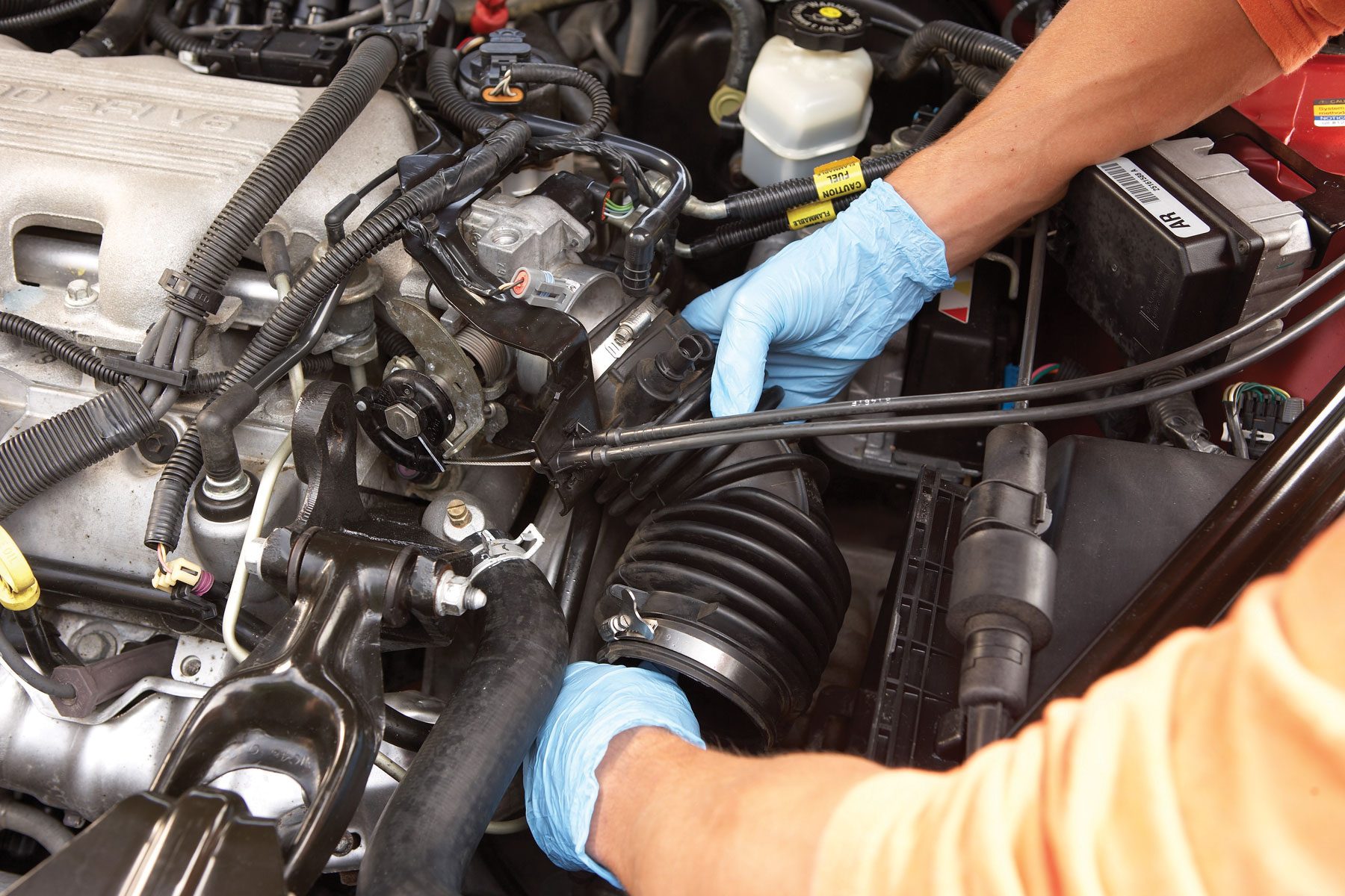 A person checking engine while wearing gloves