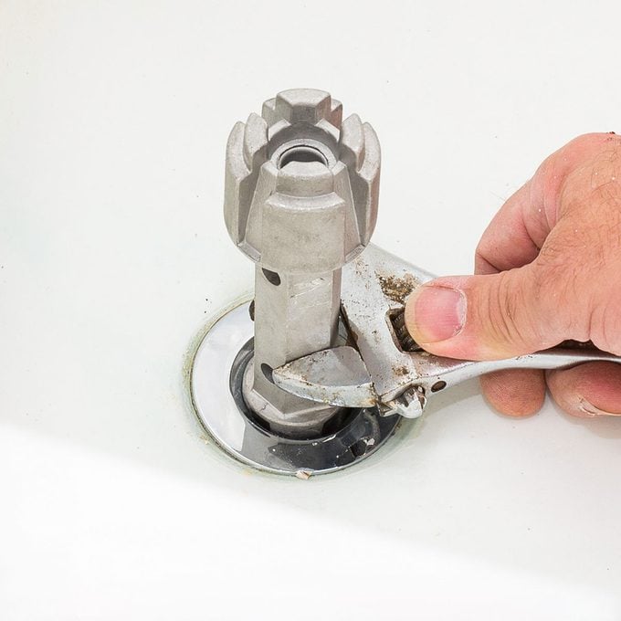 Removing Bathtub Drain Flange With Wrench And Specialty Tool