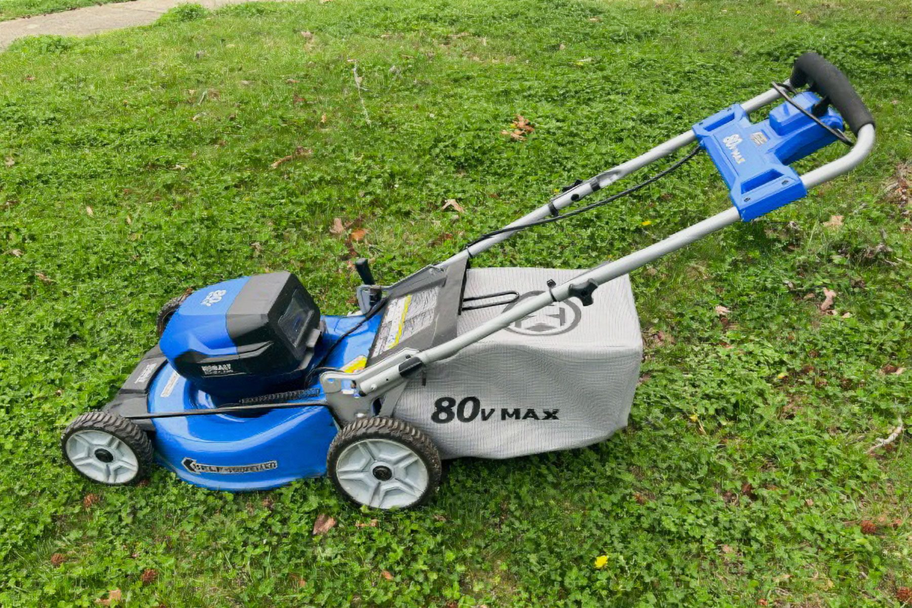 A lawn Mower outside in front yard of a house