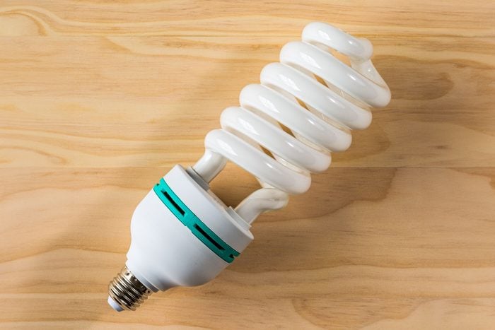 Overhead Shot Of CFL Bulb On Wooden Background