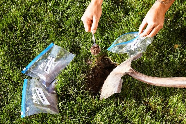 hands putting soil in small ziplock bags for testing