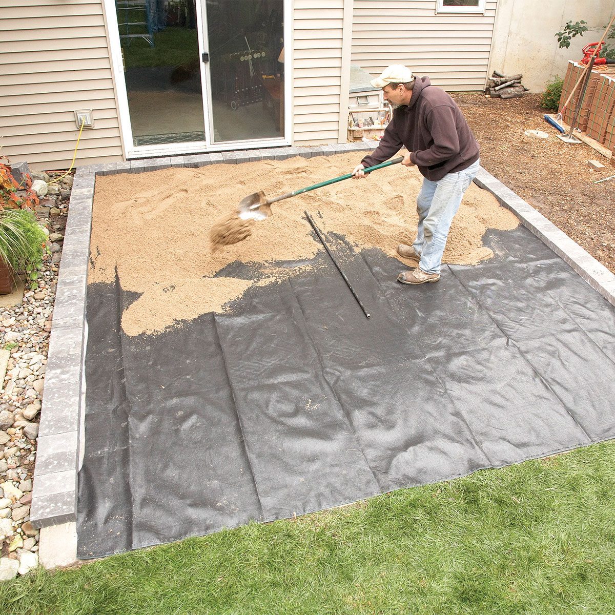 Spreading sand on layered down fabric 