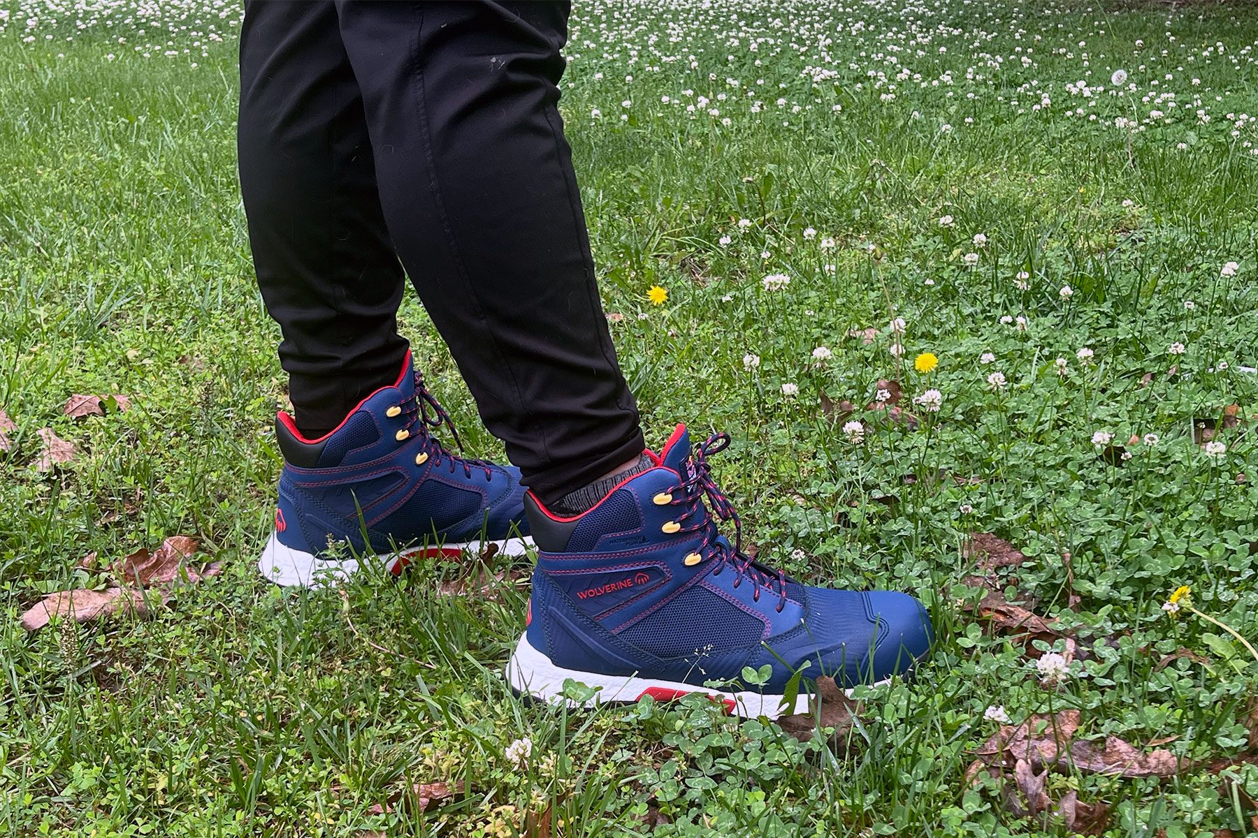 Wearing Wolverine Hiking Boots Get A Red Bull Themed Makeover and standing over grass ground